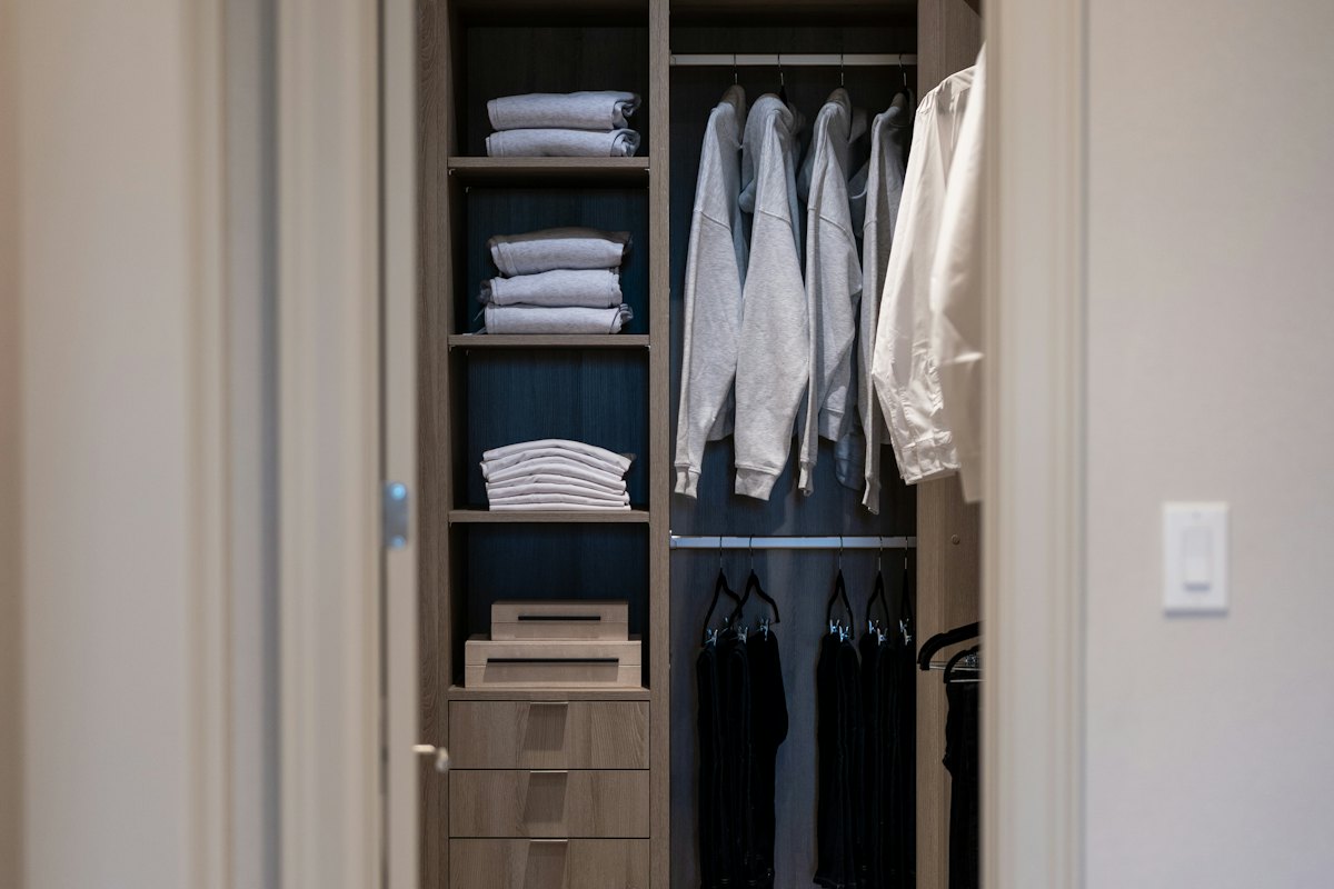 A walk-in closet with shelves, drawers and hanging space