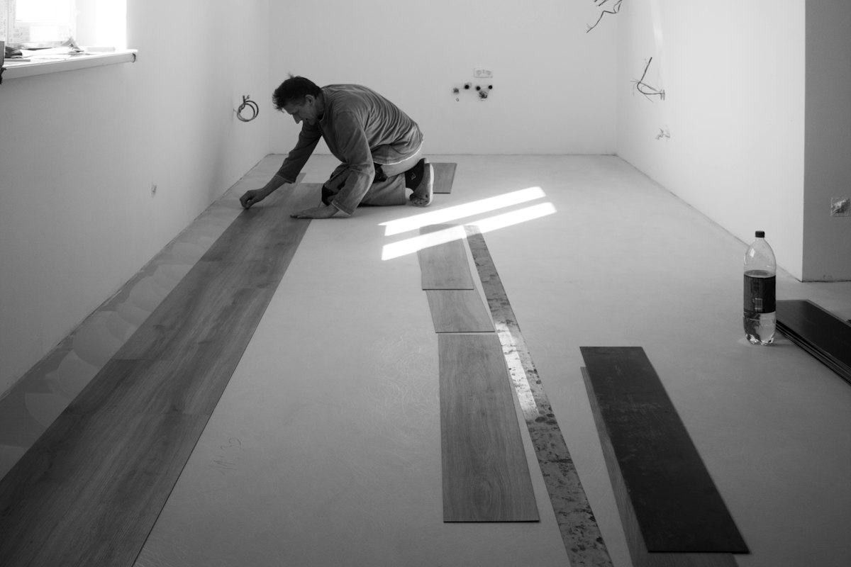 An installer laying a new floor in an empty room