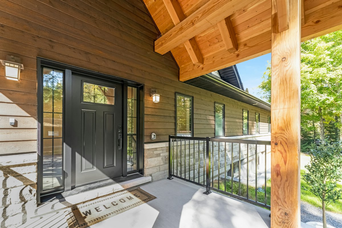 A black front door and windows on a covered porch